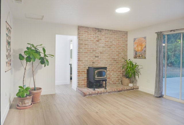 unfurnished living room featuring light hardwood / wood-style flooring and a wood stove