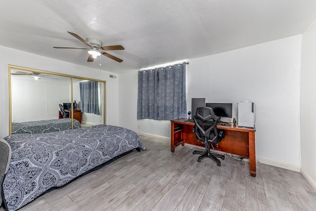 bedroom with hardwood / wood-style floors, ceiling fan, a textured ceiling, and a closet