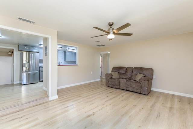 sitting room with ceiling fan and light wood-type flooring