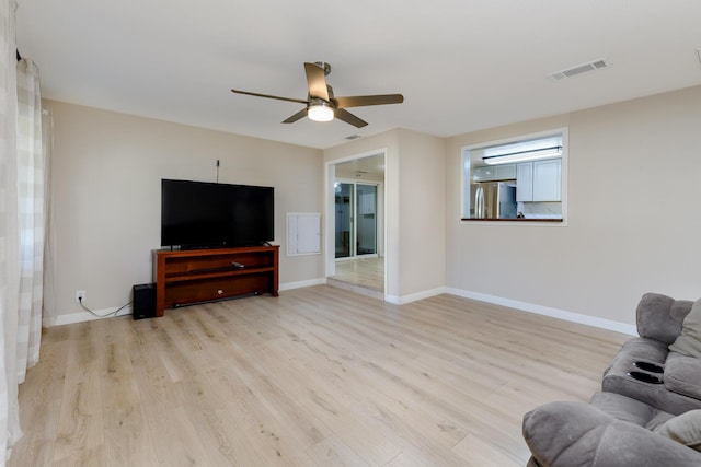 living room with ceiling fan and light wood-type flooring