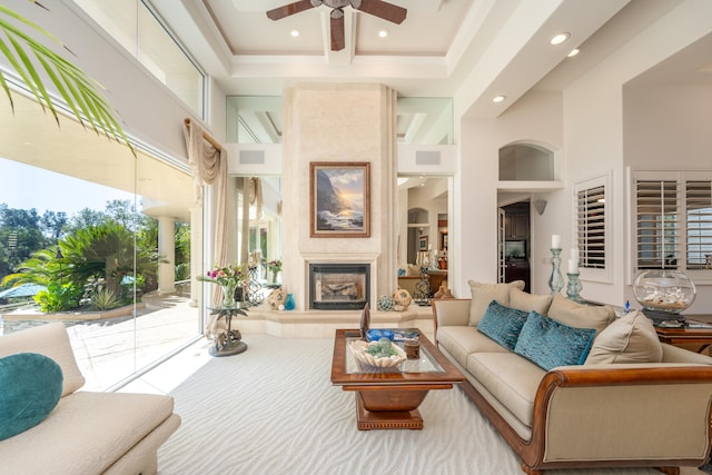 living room with ceiling fan, built in features, a towering ceiling, and a wealth of natural light