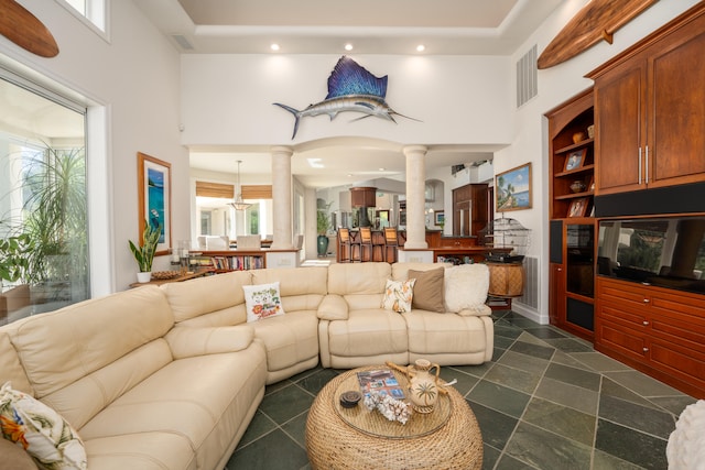 living room with decorative columns and a high ceiling