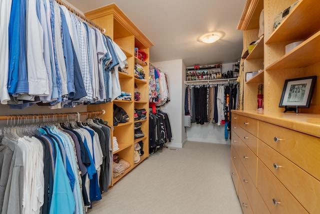 walk in closet featuring light colored carpet