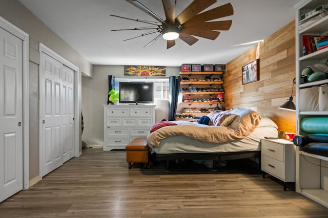 2648 Tremonto Rd, Anderson, CA 96007 - bedroom featuring wooden walls, wood finished floors, two closets, and ceiling fan