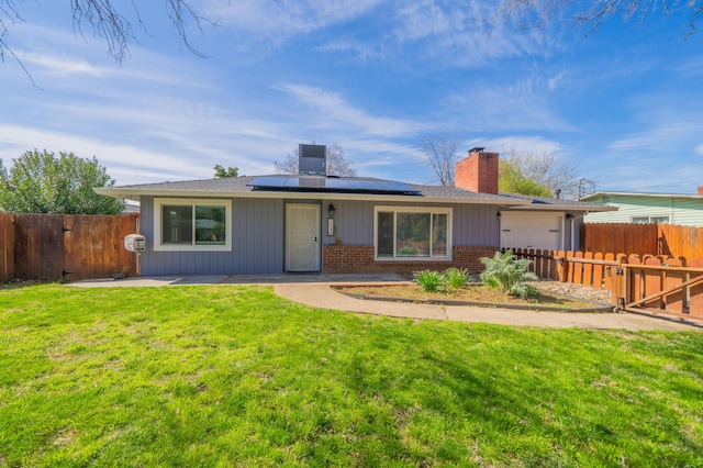 2648 Tremonto Rd, Anderson, CA 96007 - rear view of property featuring brick siding, solar panels, fence private yard, a chimney, and a yard
