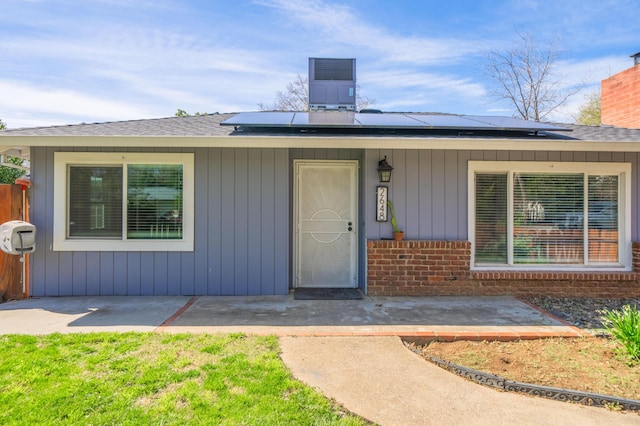 2648 Tremonto Rd, Anderson, CA 96007 - doorway to property featuring roof mounted solar panels and a chimney