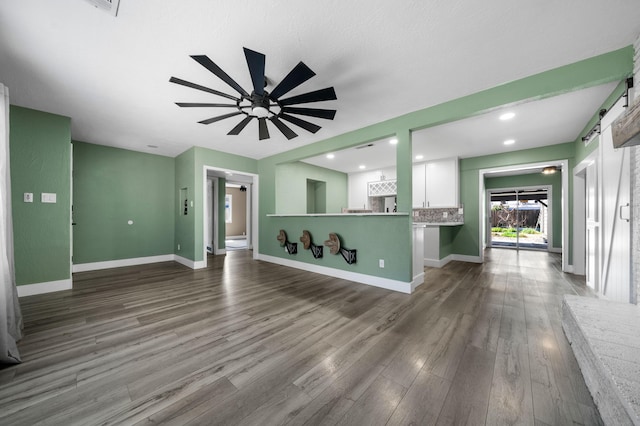 2648 Tremonto Rd, Anderson, CA 96007 - unfurnished living room featuring ceiling fan, a barn door, baseboards, and wood finished floors
