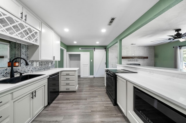 2648 Tremonto Rd, Anderson, CA 96007 - kitchen featuring black appliances, a sink, tasteful backsplash, a barn door, and white cabinets