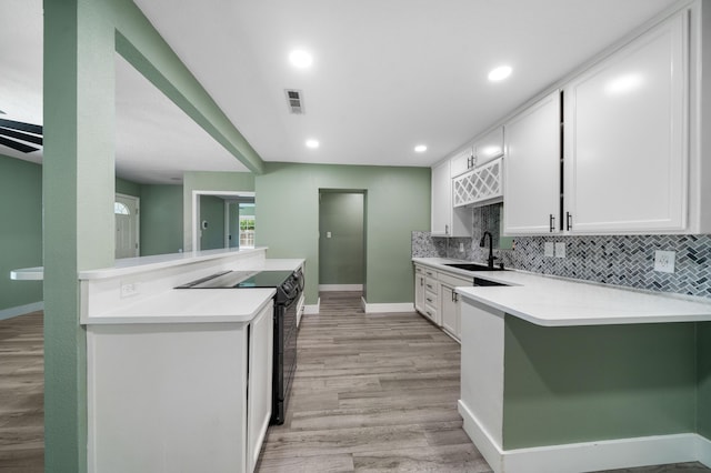 2648 Tremonto Rd, Anderson, CA 96007 - kitchen featuring visible vents, black electric range, a sink, a peninsula, and light countertops