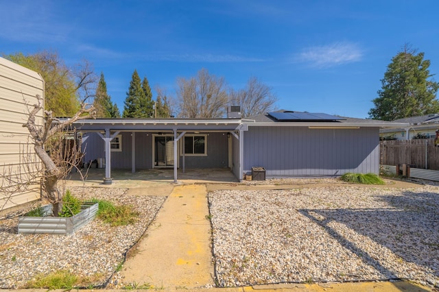 2648 Tremonto Rd, Anderson, CA 96007 - back of house with an attached carport, a patio, fence, concrete driveway, and roof mounted solar panels