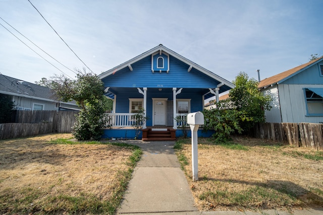 bungalow-style home with covered porch and a front yard