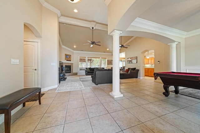 playroom featuring light tile patterned floors, a tiled fireplace, a high ceiling, pool table, and crown molding