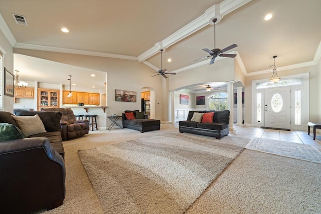 carpeted living room featuring ceiling fan, beamed ceiling, high vaulted ceiling, crown molding, and ornate columns