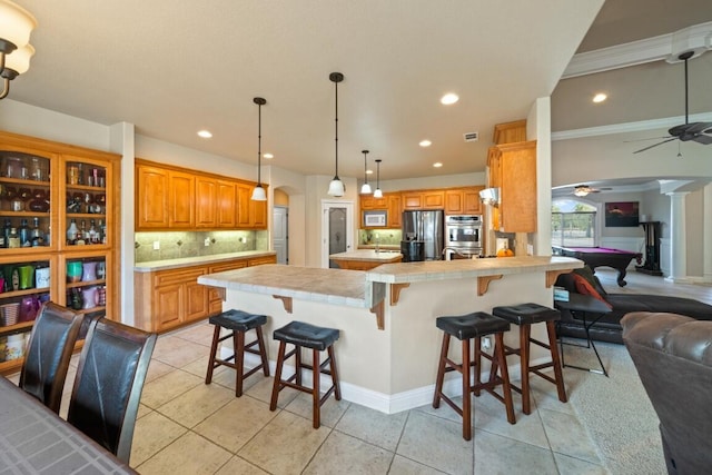 kitchen with stainless steel appliances, light tile patterned floors, pool table, a kitchen bar, and backsplash