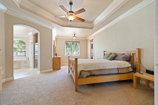 bedroom featuring ceiling fan, ensuite bath, crown molding, and light carpet