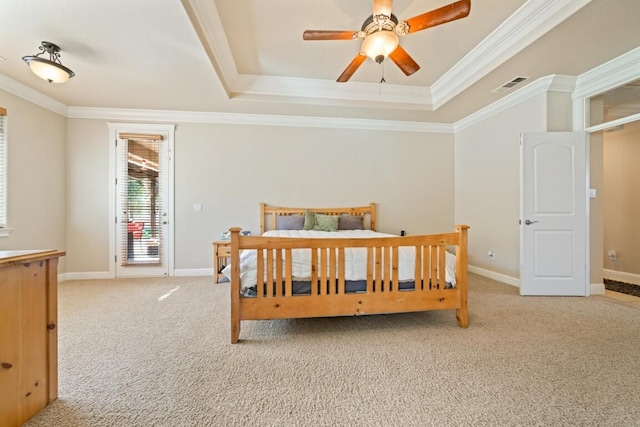 bedroom with ceiling fan, light colored carpet, a tray ceiling, and crown molding