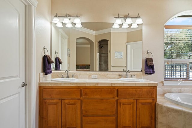 bathroom with ornamental molding, shower with separate bathtub, and vanity