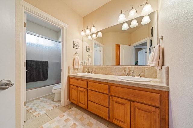 full bathroom featuring vanity, tile patterned flooring, toilet, and bath / shower combo with glass door