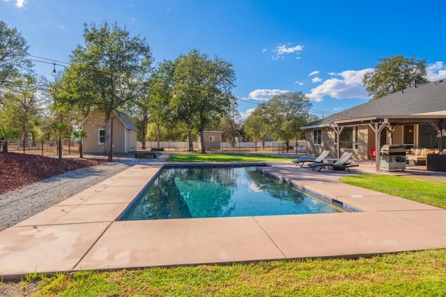 view of swimming pool with a patio and a storage shed