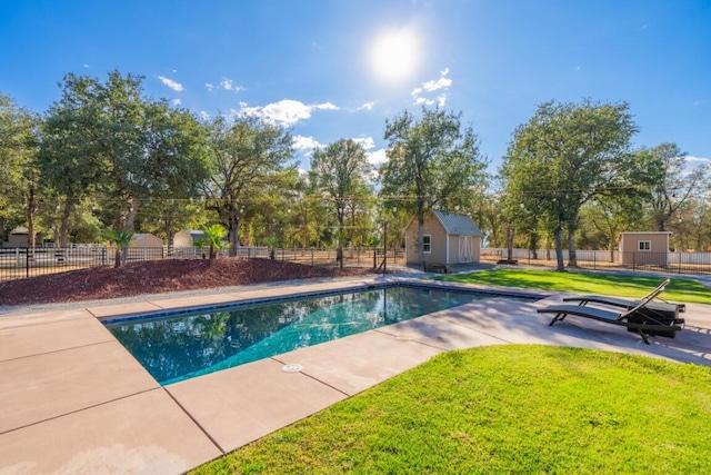 view of pool with a shed, a patio, and a lawn