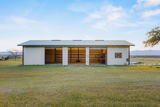 view of outdoor structure with a yard and a mountain view