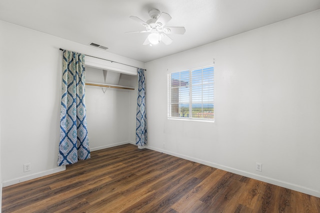 unfurnished bedroom with a closet, dark hardwood / wood-style flooring, and ceiling fan