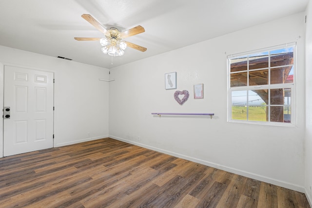 spare room with dark hardwood / wood-style flooring and ceiling fan