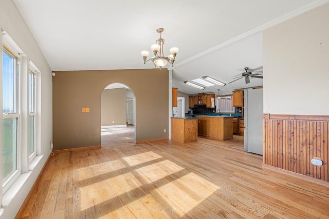 kitchen featuring light wood-type flooring, tasteful backsplash, vaulted ceiling, kitchen peninsula, and white fridge