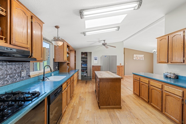 kitchen with sink, black appliances, lofted ceiling with skylight, a center island, and light wood-type flooring