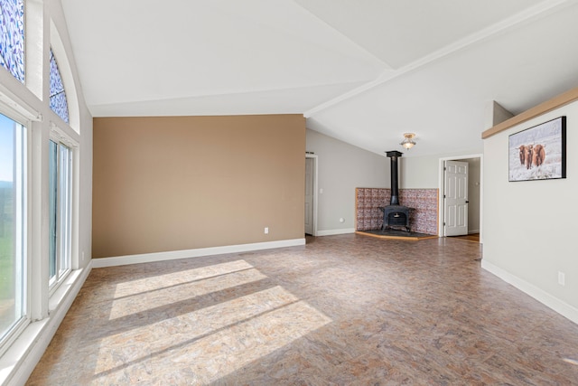 unfurnished living room featuring a wood stove and vaulted ceiling