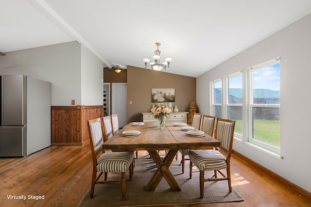 dining space with lofted ceiling, a mountain view, hardwood / wood-style floors, and a chandelier