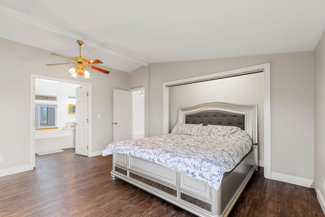 bedroom featuring ceiling fan, connected bathroom, dark hardwood / wood-style floors, and vaulted ceiling