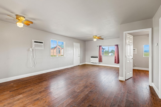 unfurnished living room with dark wood-type flooring, heating unit, a wall mounted AC, and ceiling fan