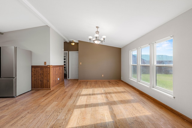 interior space with light wood-type flooring, a mountain view, vaulted ceiling, and a chandelier