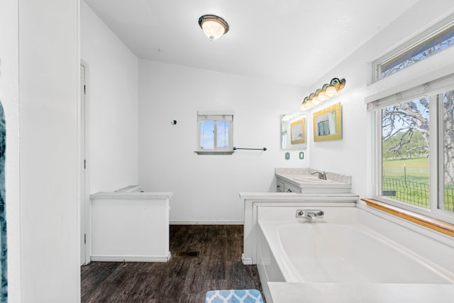 bathroom with lofted ceiling, a tub to relax in, hardwood / wood-style flooring, and vanity