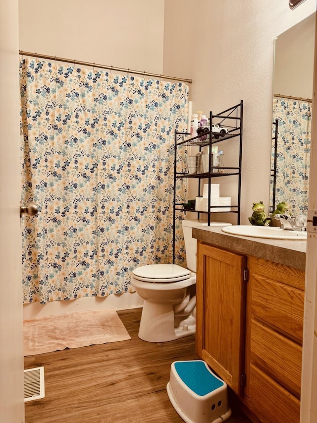 bathroom featuring wood-type flooring, vanity, and toilet