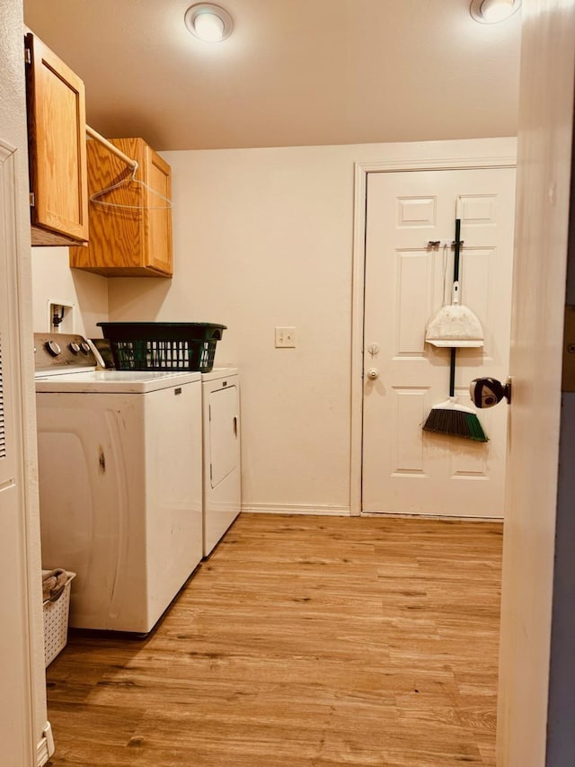 washroom featuring cabinets, light wood-type flooring, and washer and dryer