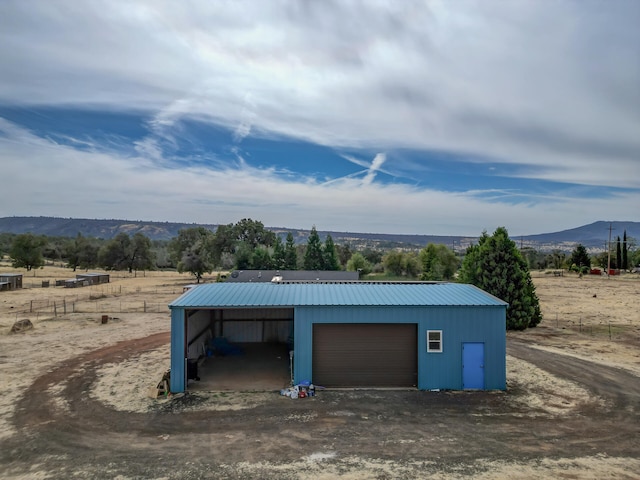 garage with a rural view and a mountain view