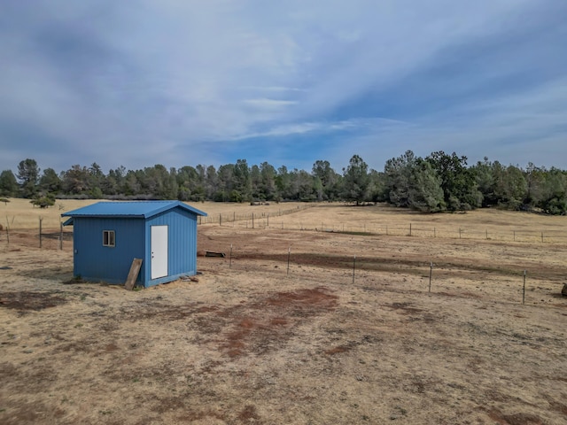 view of yard with a rural view and a storage unit