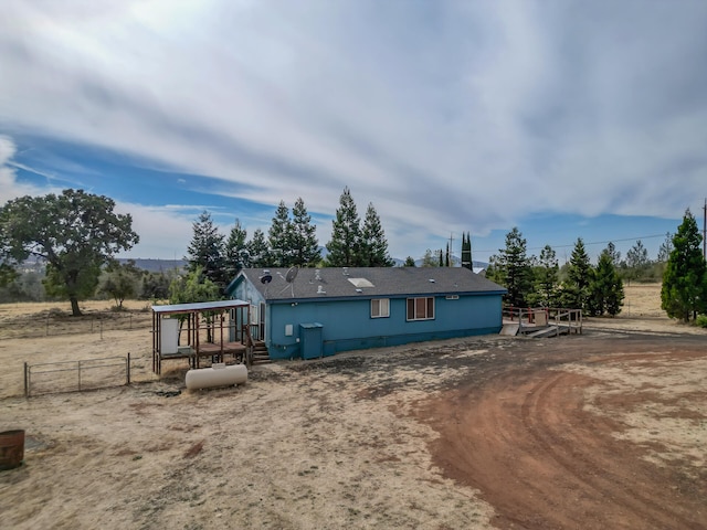 rear view of house featuring a rural view