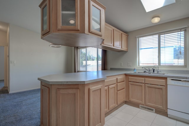 kitchen featuring a skylight, kitchen peninsula, plenty of natural light, and dishwasher