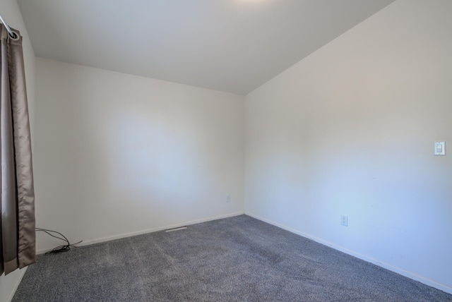 spare room featuring lofted ceiling and carpet