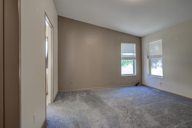 spare room featuring lofted ceiling and carpet