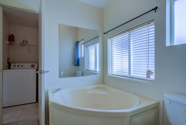 bathroom featuring tile patterned flooring, toilet, a washtub, and washer / dryer