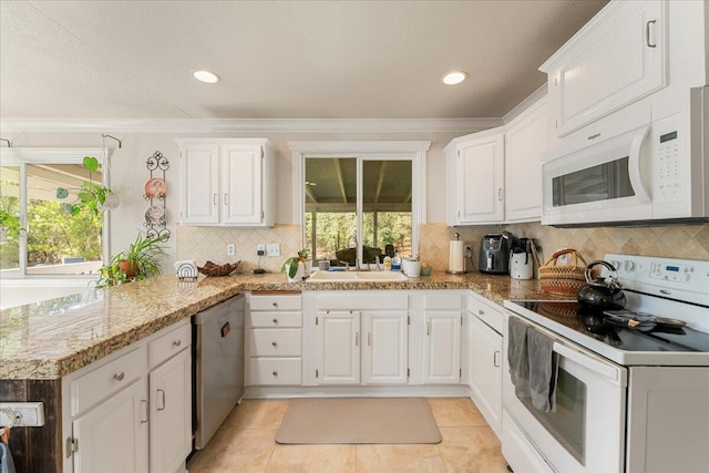 kitchen featuring light stone counters, white cabinets, sink, white appliances, and crown molding