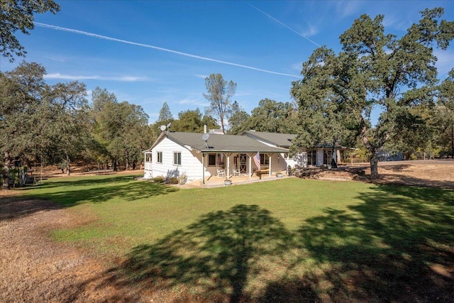 rear view of property with a lawn and a patio