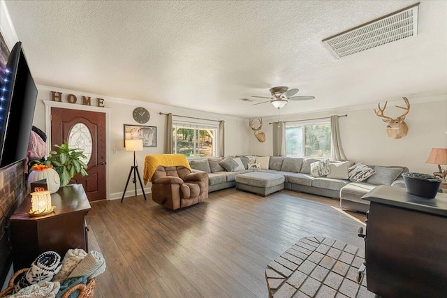 living room featuring ornamental molding, ceiling fan, hardwood / wood-style floors, and a textured ceiling