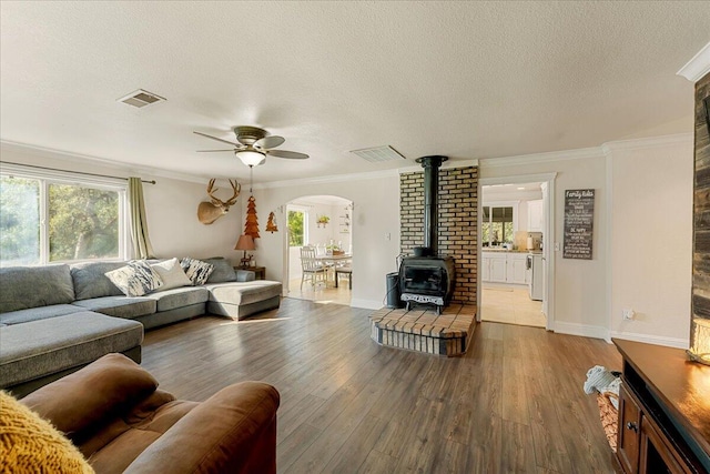 living room featuring crown molding, hardwood / wood-style flooring, and a healthy amount of sunlight