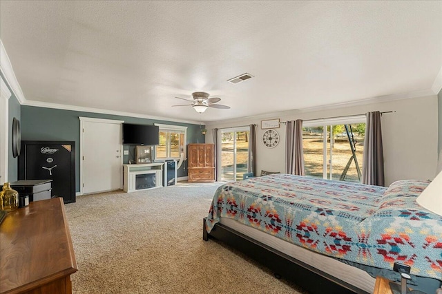 carpeted bedroom featuring ornamental molding, access to exterior, ceiling fan, and a textured ceiling