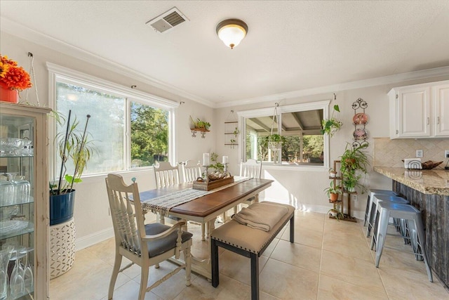 dining space featuring crown molding and light tile patterned floors